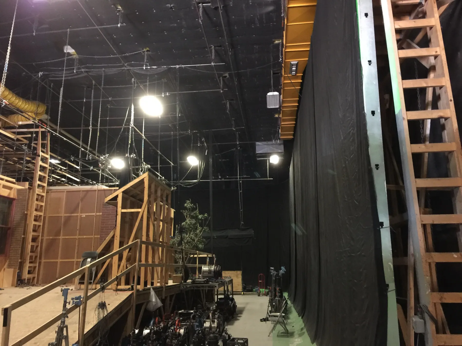 Inside a working soundstage: set builds, rigging, and ladders under stage light at Studio Institute Global.